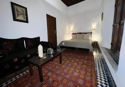 a living room with a bed and a couch at Riad Dezayn in Fès