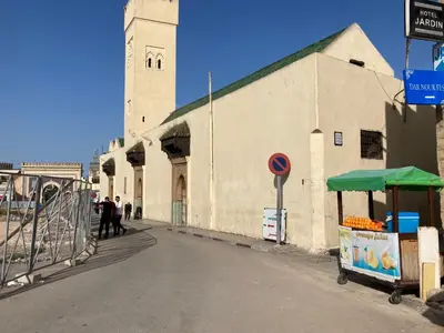 a building with a fruit stand on the side of a street at Dar Zin in Fès