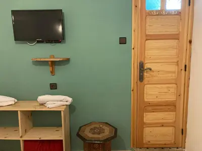 a room with a television on a green wall at Dar Zin in Fès