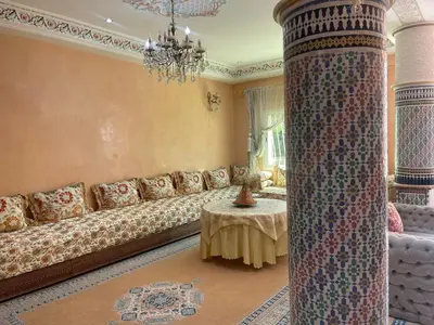 a living room with a long couch and a table at Beautiful & Comfortable Apartment in Fes in Fès