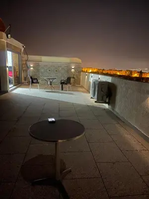 a table and chairs on a patio at night at Beautiful & Comfortable Apartment in Fes in Fès