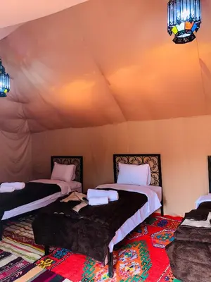 a room with two beds in a tent at Sahara wellness camp in Merzouga