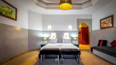 a bedroom with a large bed and a couch at Palmeraie Dar Atlas - Luxury Houses in Marrakech