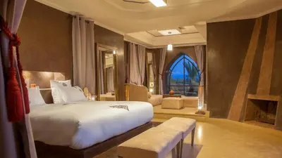 a bedroom with a large bed and a living room at Palmeraie Dar Atlas - Luxury Houses in Marrakech