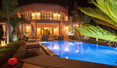 a house with a swimming pool at night at Palmeraie Dar Atlas - Luxury Houses in Marrakech