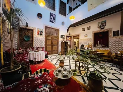 a living room filled with furniture and a potted plant at Dar Ahl Tadla in Fès