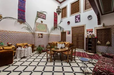 a living room with a table and chairs at Dar Ahl Tadla in Fès