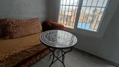 a table in a room with a couch and a window at Dar Ahl Tadla in Fès
