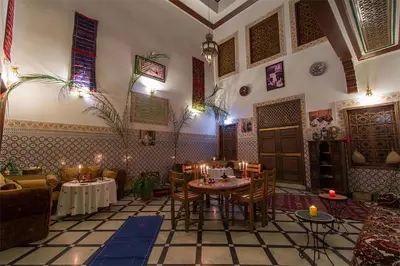 a restaurant with a table and chairs and candles at Dar Ahl Tadla in Fès