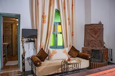 a living room with a couch and a fireplace at Le Petit Riad Maison d'hôtes in Ouarzazate