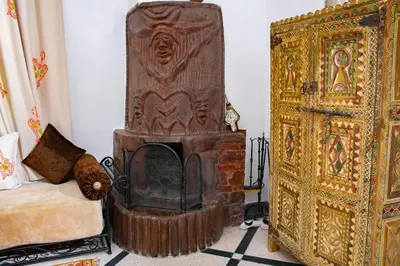 a room with a fireplace next to a bed at Le Petit Riad Maison d'hôtes in Ouarzazate