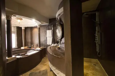 a bathroom with a large tub and a large mirror at Riad Mayfez Suites & Spa in Fès