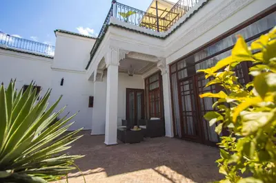 a courtyard of a white house with a balcony at Riad Mayfez Suites & Spa in Fès