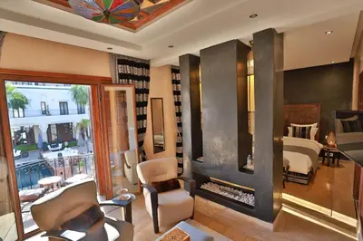 a room with a bedroom with a bed and a fireplace at Riad Mayfez Suites & Spa in Fès