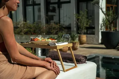 a woman sitting next to a table with a bowl of food at Riad Mayfez Suites & Spa in Fès