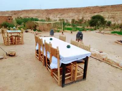 a table and chairs sitting in a dirt field at Amoudou Lodge Camp in Tissint