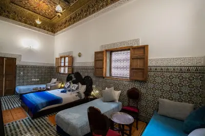a bedroom with two beds and a couch at Riad Fes Iline in Fès