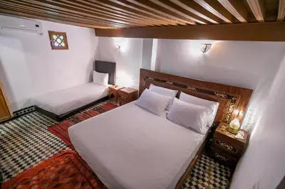 a small room with a bed and a bed and a couch at Riad Fes Iline in Fès