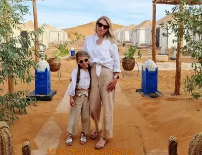 a woman standing next to a little boy in the desert at Milky Way Desert Camp in Merzouga