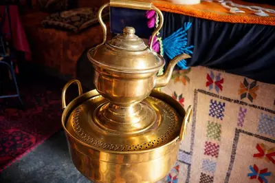 a golden tea kettle sitting on top of a table at La Vallée des Dunes - Auberge, randonnées et circuits in Merzouga