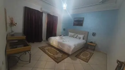 a bedroom with a white bed in a room at Kasbat Aferdou in Er Rachidia