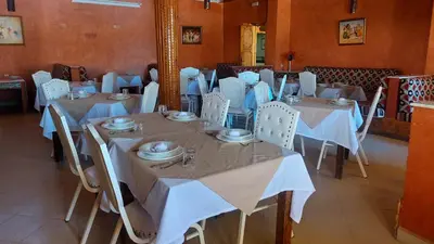 a dining room with tables and chairs with white table cloth at Kasbat Aferdou in Er Rachidia