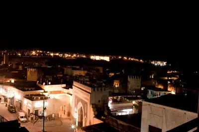 a view of a city at night with lights at Hotel Bab Boujloud in Fès
