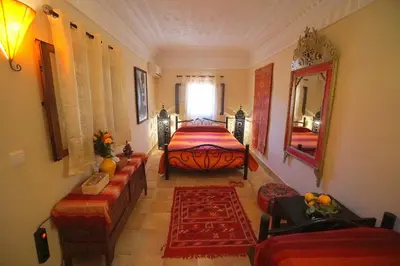 a bedroom with a bed and a large mirror at Riad Dar Rita in Ouarzazate