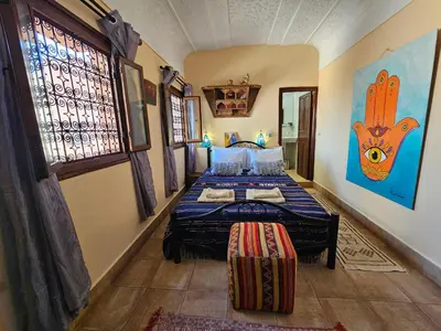 a bedroom with a bed in the corner of a room at Riad Dar Rita in Ouarzazate