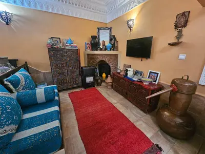 a living room with a couch and a fireplace at Riad Dar Rita in Ouarzazate