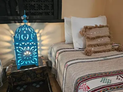 a bedroom with a bed with a blue decoration on it at Riad Dar Rita in Ouarzazate