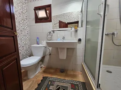 a bathroom with a toilet and a sink and a shower at Riad Dar Rita in Ouarzazate