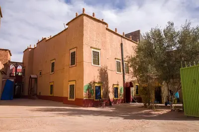 a large brick building with graffiti on the side of it at Kasbah Omari in Tinerhir