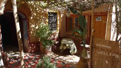 a porch of a house with a bench and plants at Kasbah Omari in Tinerhir
