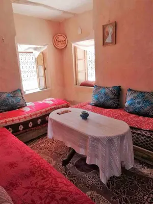 a room with two beds and a table in it at Kasbah Omari in Tinerhir