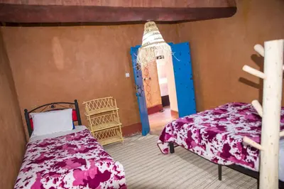 a bedroom with a bed and a small room with a door at Kasbah Omari in Tinerhir
