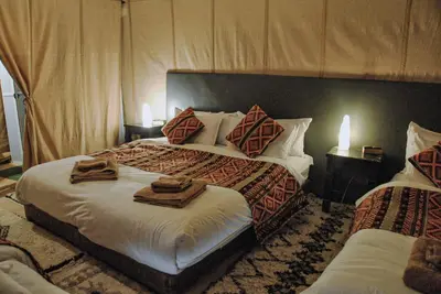 a bedroom with two beds with towels on them at Camel Trips Luxury Camp in Merzouga