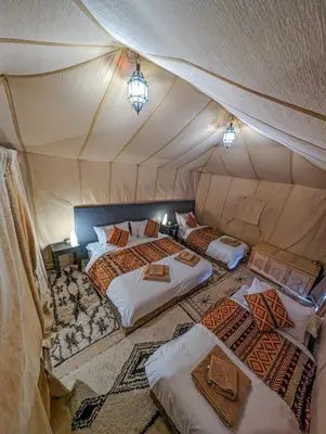 a room with two beds in a tent at Camel Trips Luxury Camp in Merzouga