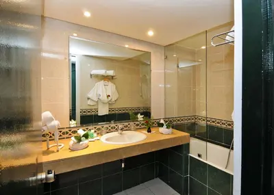 a bathroom with a sink and a mirror at Hôtel Volubilis in Fès