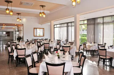 a banquet hall with white tables and chairs at Hôtel Volubilis in Fès