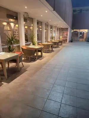a large room with tables and chairs and tables at Hôtel Volubilis in Fès