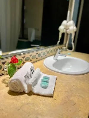 a bathroom counter with a towel and a sink at Hôtel Volubilis in Fès