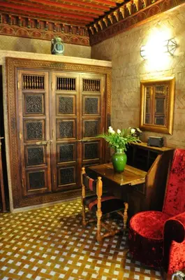 a living room with a desk and a chair and a table at Riad La Maison Verte in Fès