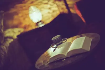 an open book sitting on a table with a candle at Riad La Maison Verte in Fès