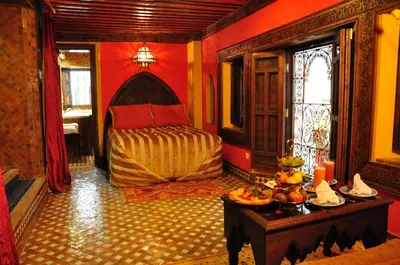 a bedroom with a bed and a table with food on it at Riad La Maison Verte in Fès
