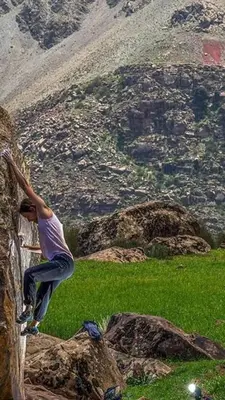 a man is climbing a rock on a mountain at Chalet tizrag in Oukkainrdem