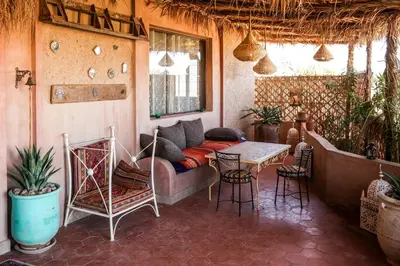 a living room with a couch and a table and chairs at Dune House in Merzouga