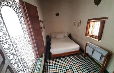 a small bedroom with a bed and a window at Dar Houdou in Fès