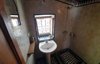 a small bathroom with a sink and a window at Dar Houdou in Fès