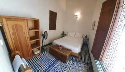 a small bedroom with a bed and a table at Dar Houdou in Fès